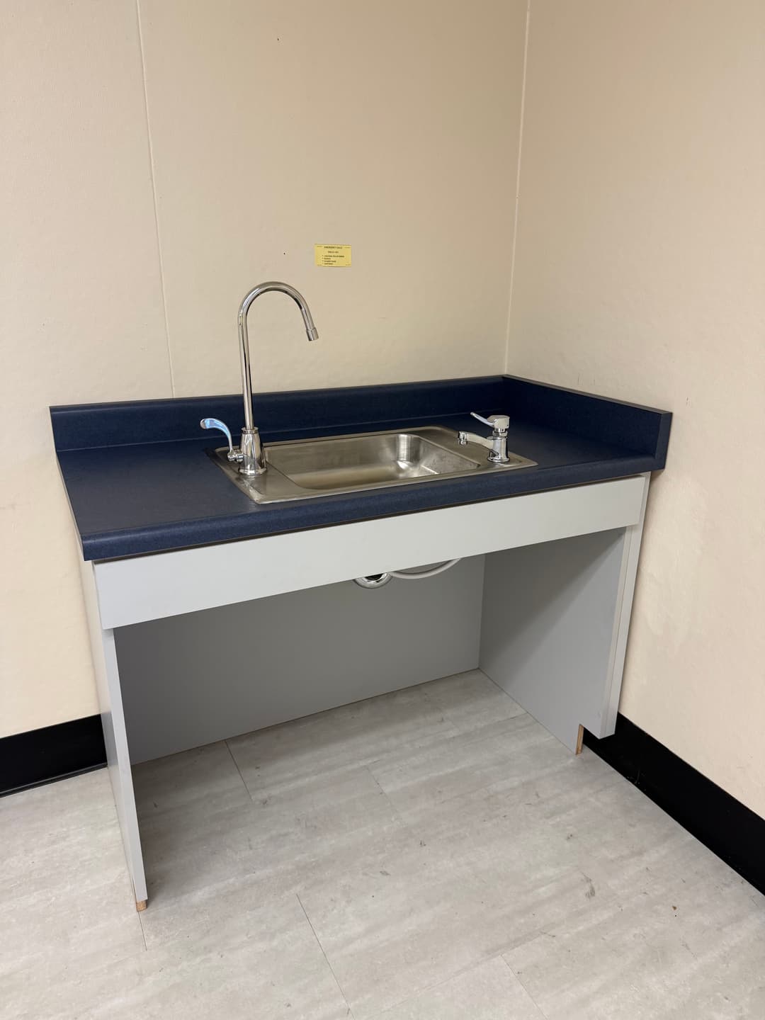 modern kitchen sink with stainless steel basin and faucet on blue countertop