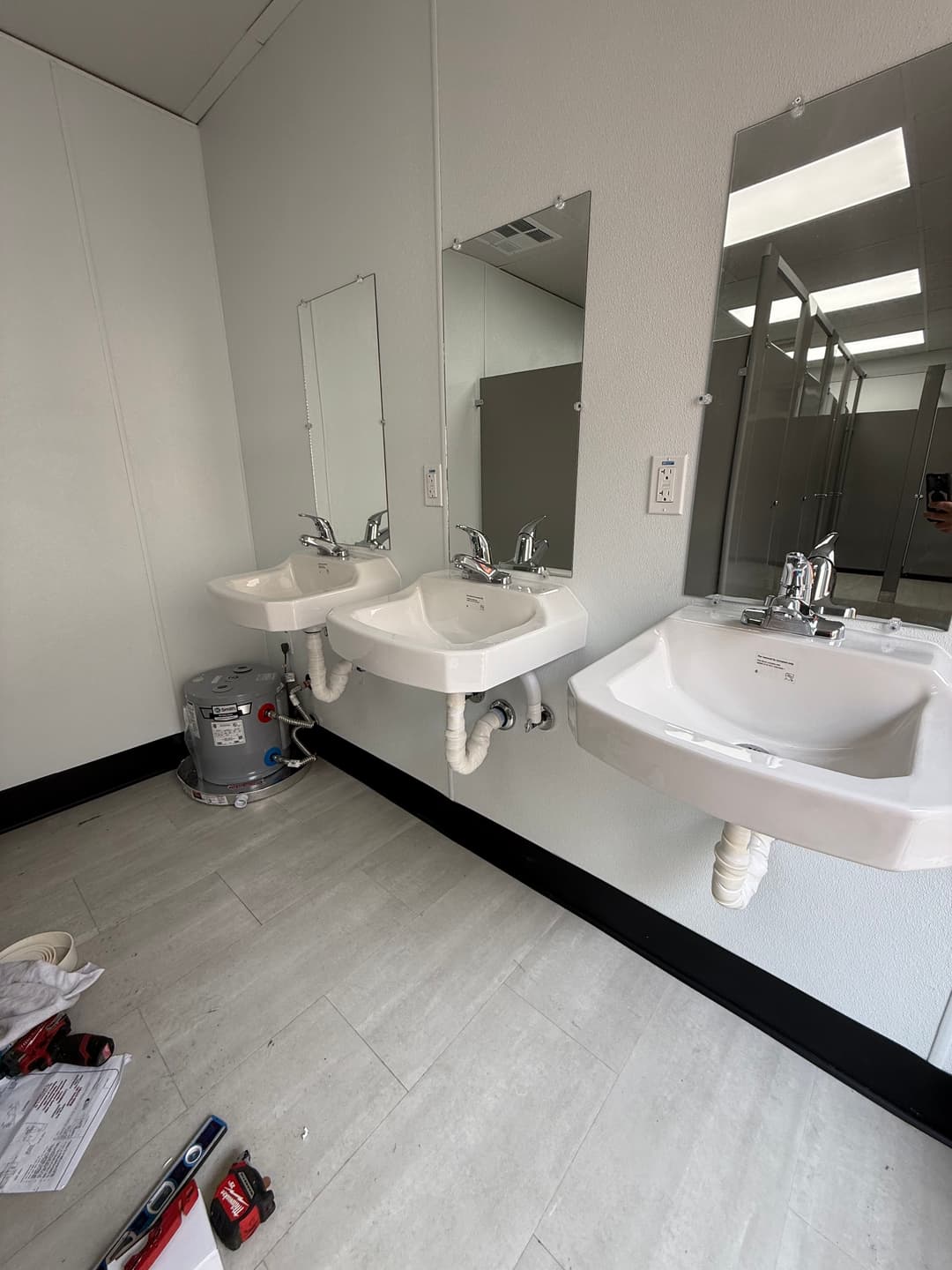 three wall-mounted sinks with mirrors in a modern restroom interior