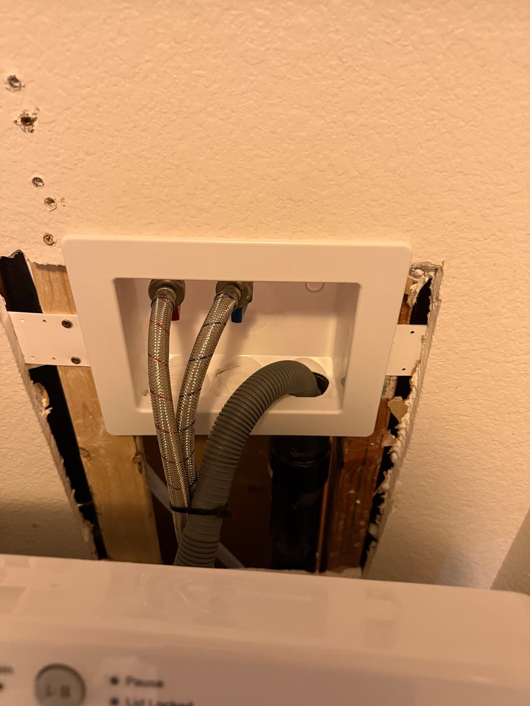 Washing machine water supply connections in a wall with exposed plumbing.