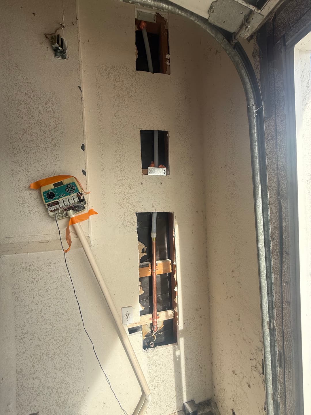 Exposed wall with electrical outlets and wiring in a maintenance space.