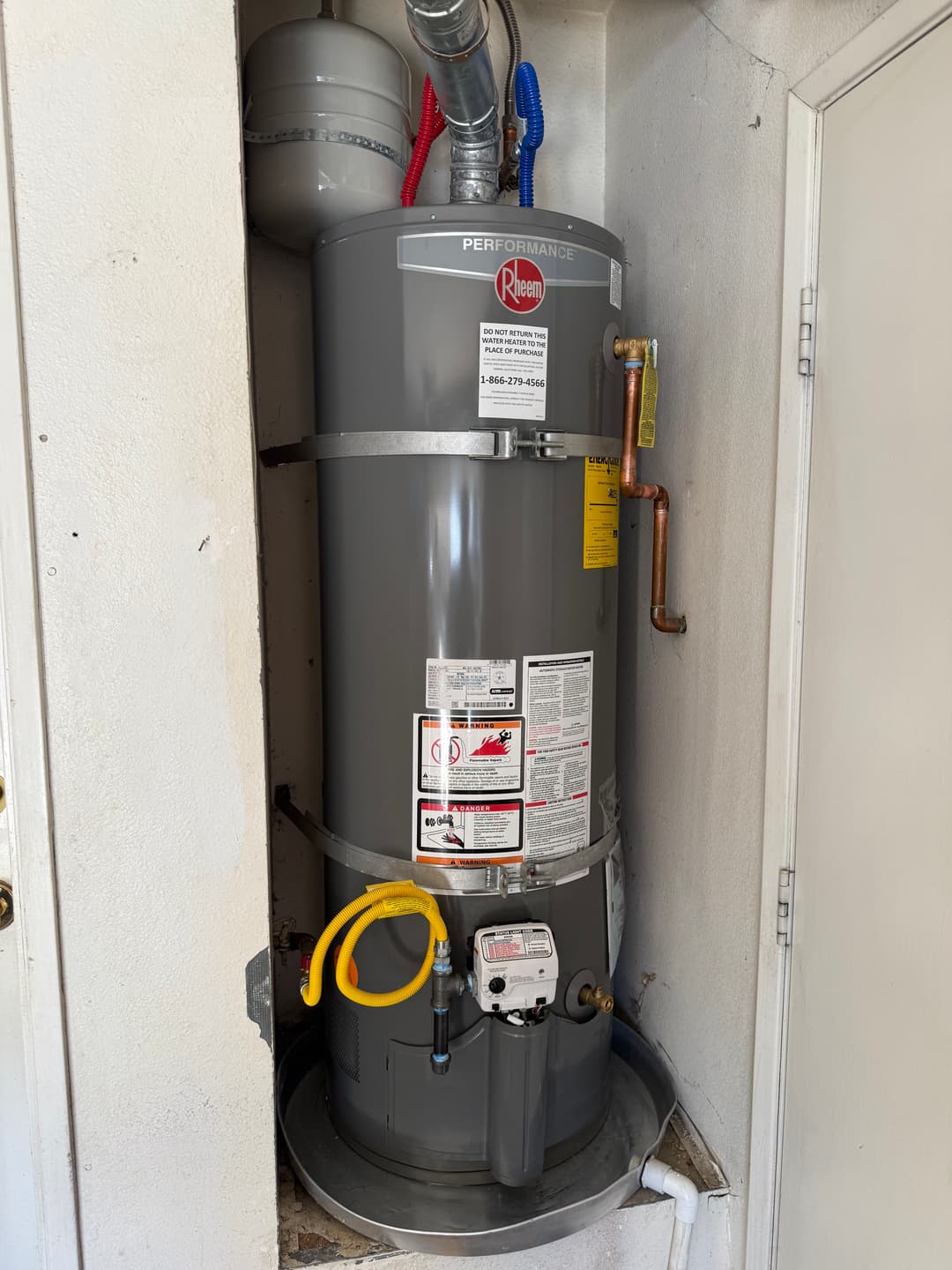 Rheem performance water heater installed in a compact utility space.