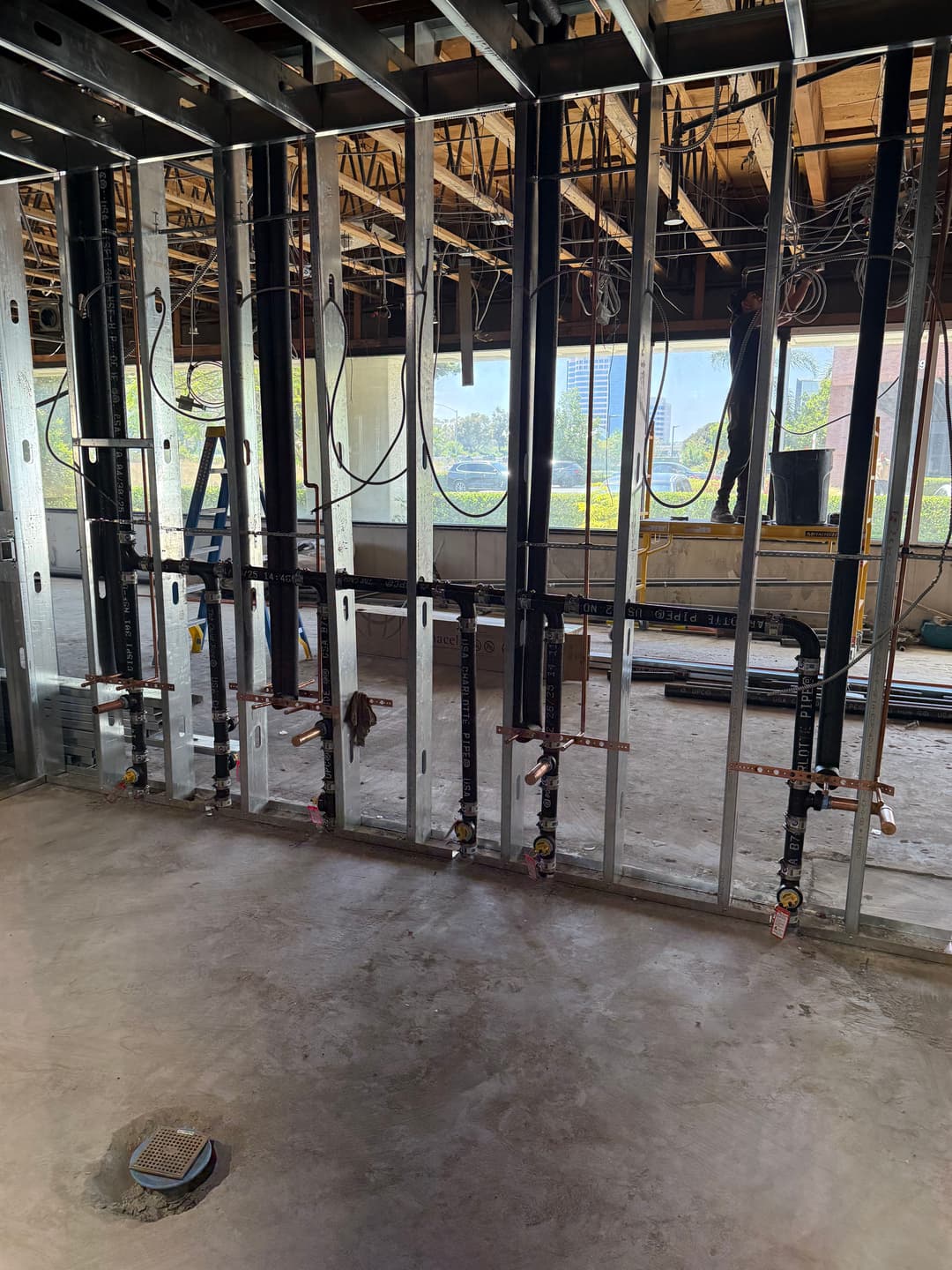 modern interior construction with metal framing, plumbing lines, and unfinished walls