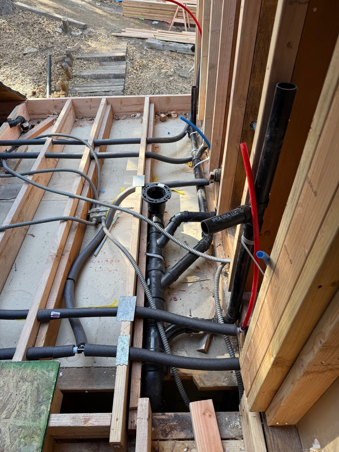 Plumbing installation with pipes and fittings in a construction setting.